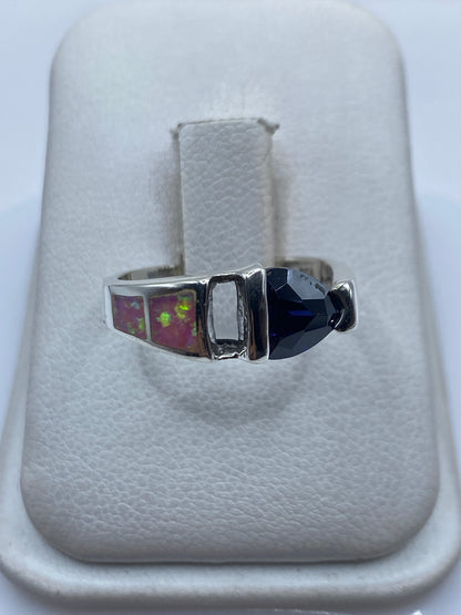 Anillo de plata con ópalo de fuego rosa en mano de mujer, mostrando el brillo vibrante de la piedra