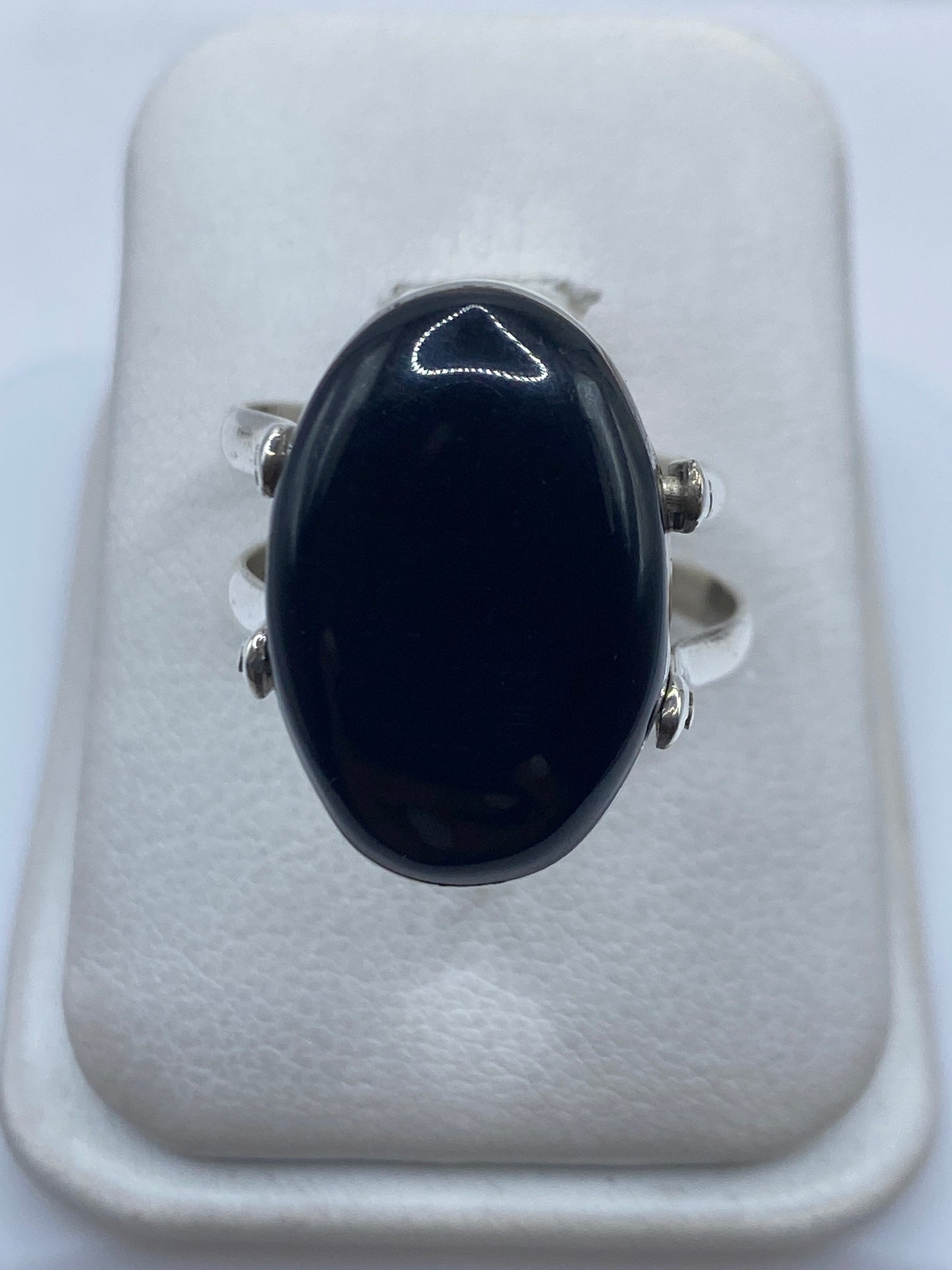 Anillo de plata .925 con ónix negro pulido en la mano de una mujer