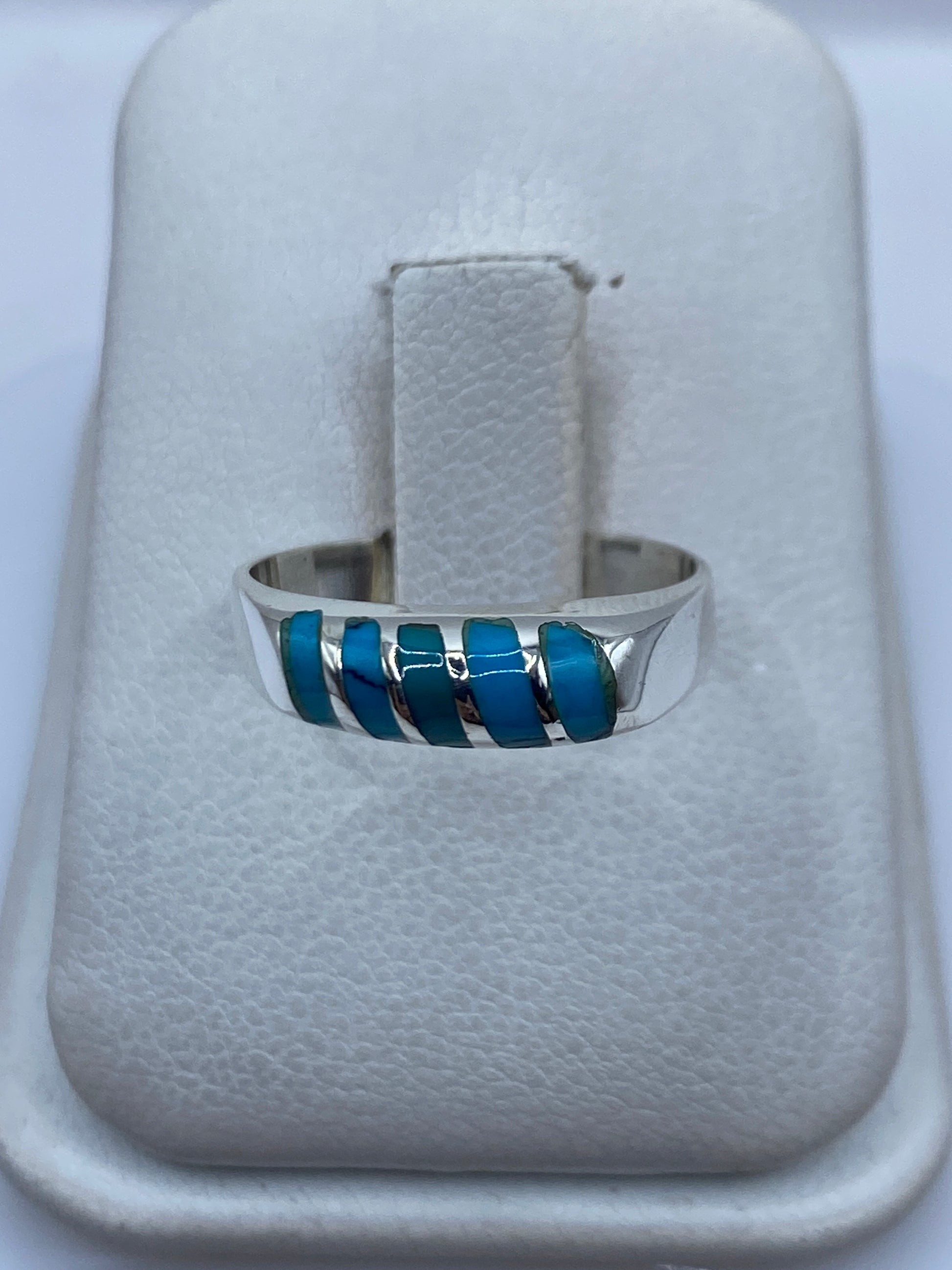 Anillo de plata con cinco incrustaciones de turquesa azul cielo en la mano