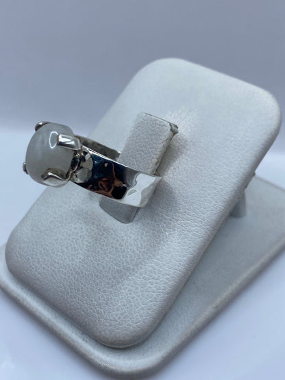 Anillo de plata minimalista con piedra blanca, vista lateral mostrando el perfil del montaje