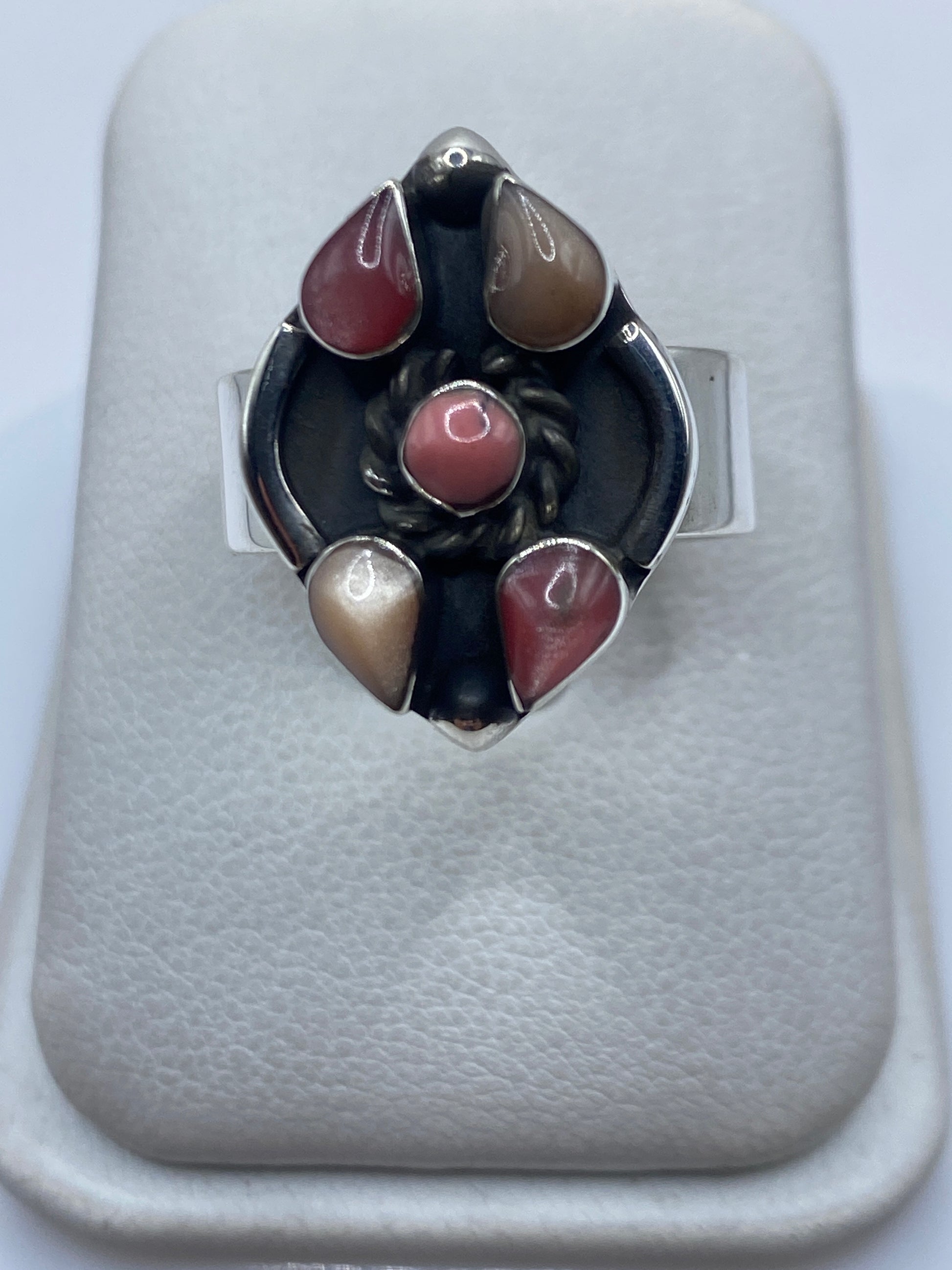 Anillo ajustable de plata con piedra rosa incrustada visto desde arriba en estuche blanco