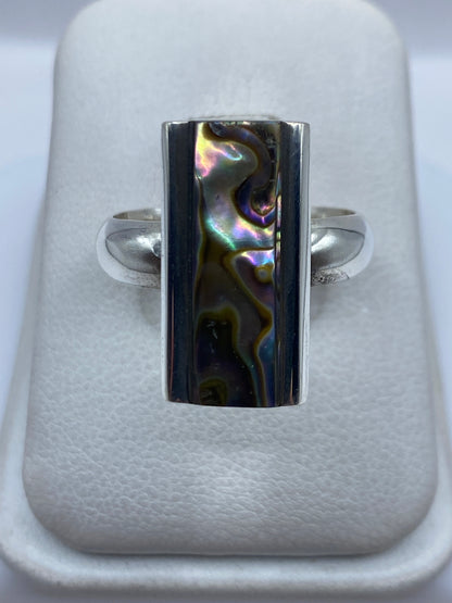 Anillo de plata con piedra natural engastada a mano, visto de frente en presentador blanco
