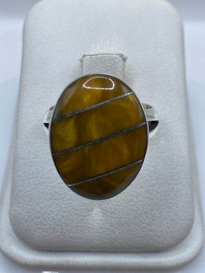 Anillo de plata .925 con piedra café, visto de frente en caja blanca