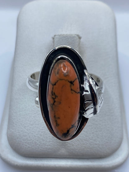 Anillo de plata .925 con piedra natural en tono cálido y vetas negras, engastada a mano