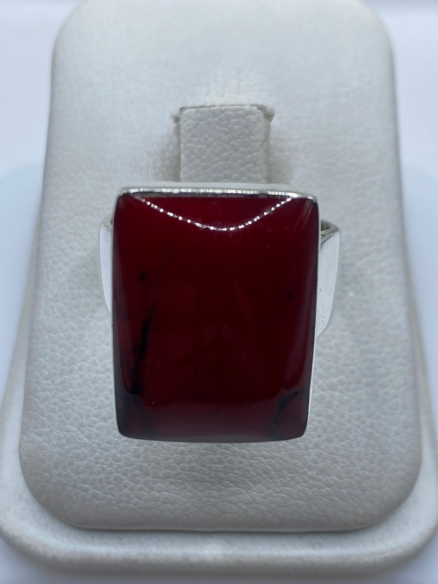 Anillo de plata .925 con coral rojo engastado, visto de frente en estuche blanco