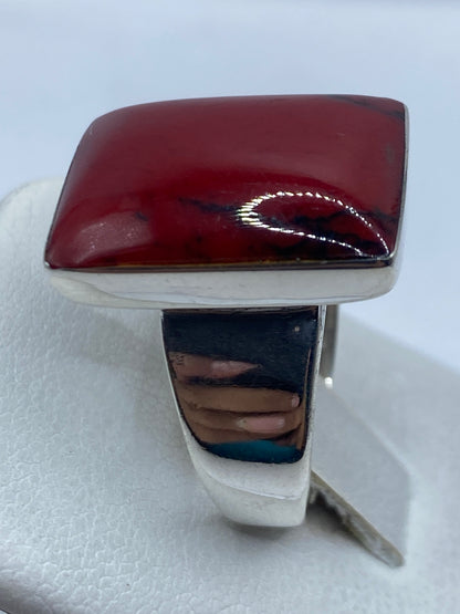 Detalle del coral rojo brillante en la mano de una mujer, tono cálido