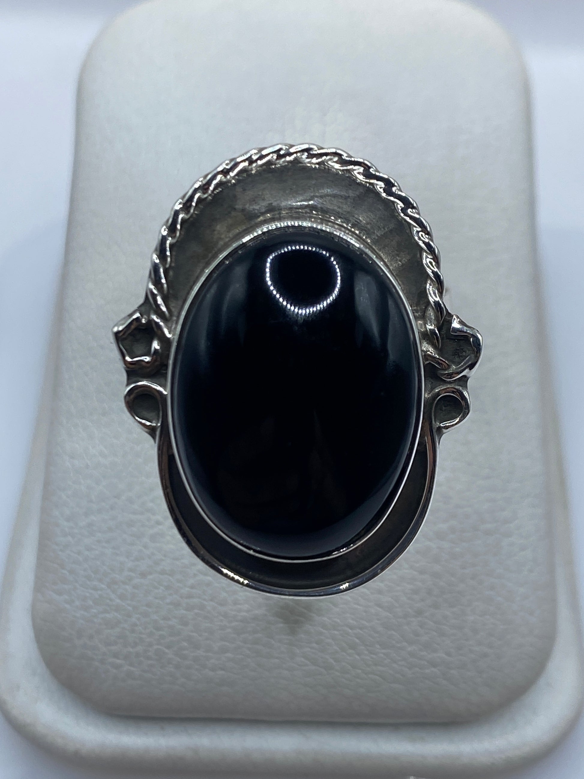Anillo de plata ajustable con ónix negro brillante, vista frontal sobre fondo blanco