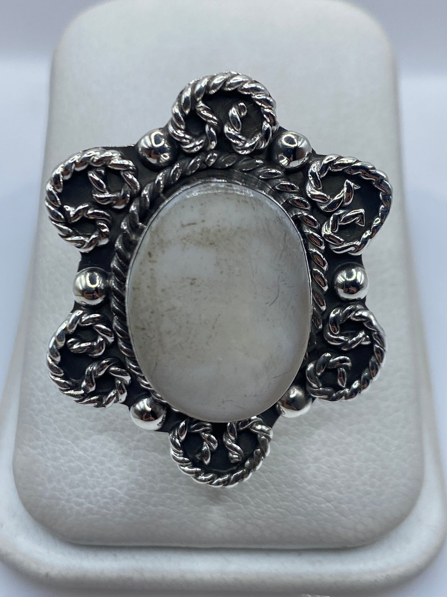 Anillo de plata con perla blanca cremosa engastada, diseño barroco ornamental sobre fondo blanco