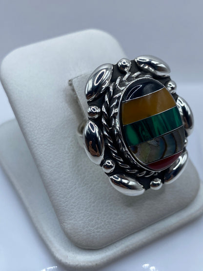 Detalle lateral del anillo ajustable mostrando el engaste a mano y las vetas de malaquita