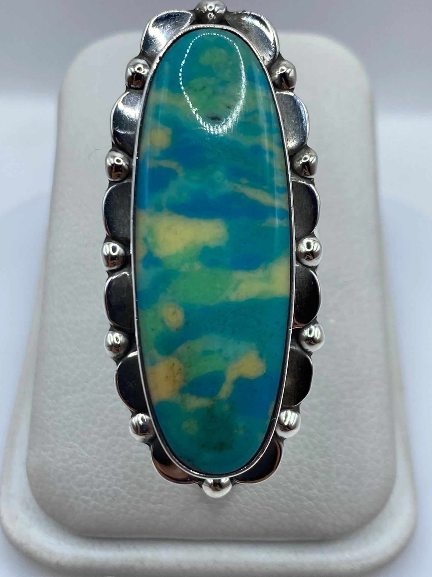 Anillo de plata .925 con piedra azul oval engastada, vista frontal sobre dedo