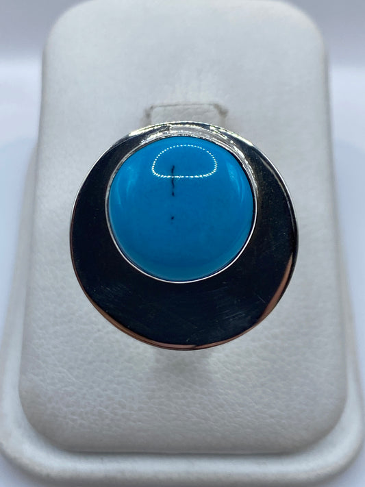 Anillo de plata ajustable con turquesa azul cielo en la mano de una mujer