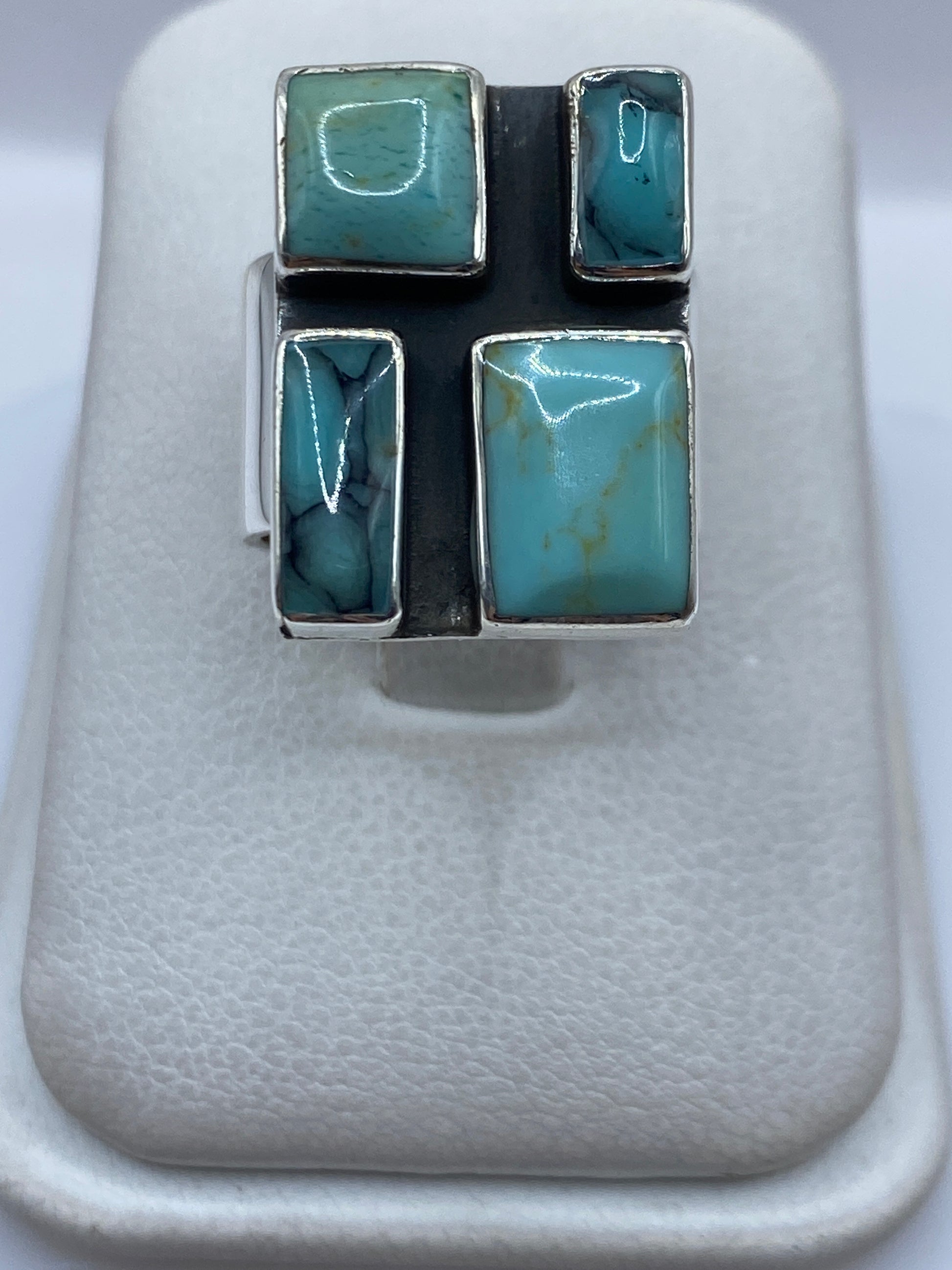 Anillo de plata con turquesa azul cielo en diseño geométrico de cuatro piedras visto desde arriba
