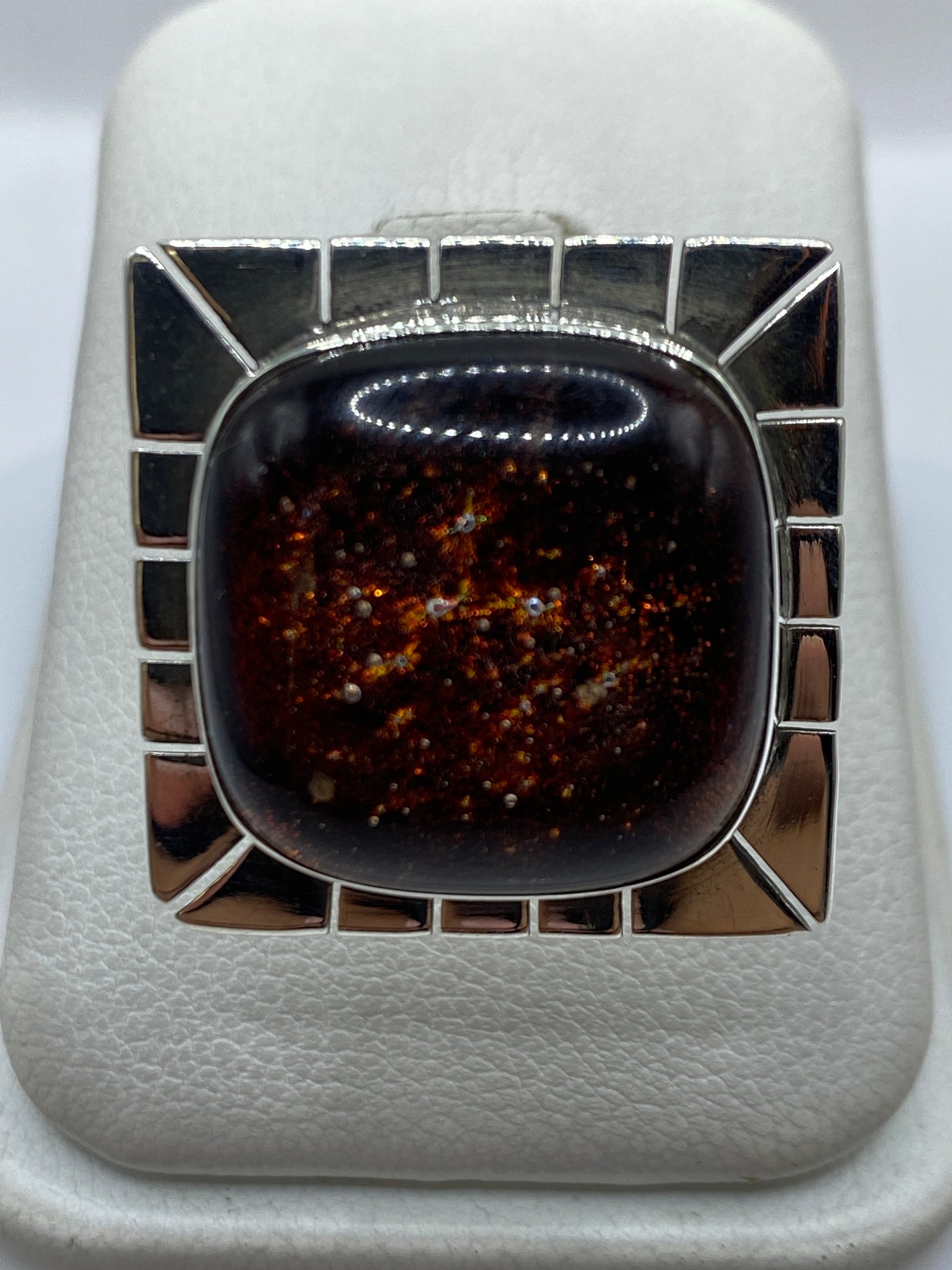 Anillo ajustable de plata con piedra incrustada en marco geométrico, vista frontal