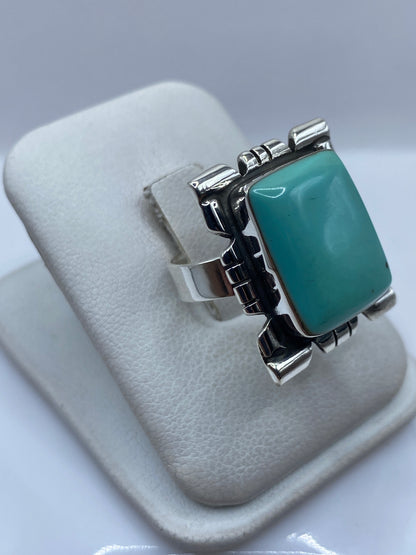 Detalle lateral del anillo ajustable mostrando el engaste de turquesa y los volúmenes geométricos de plata