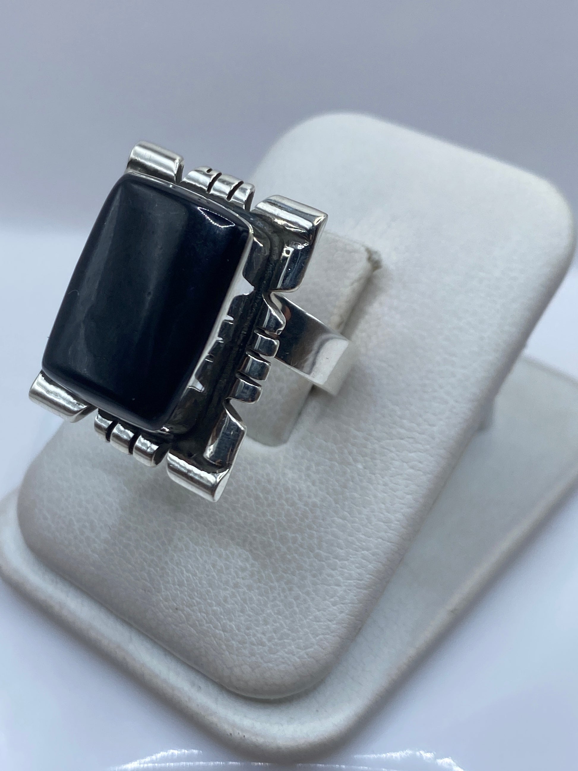 Detalle lateral del anillo mostrando el engaste a mano del onix y las líneas geométricas de plata