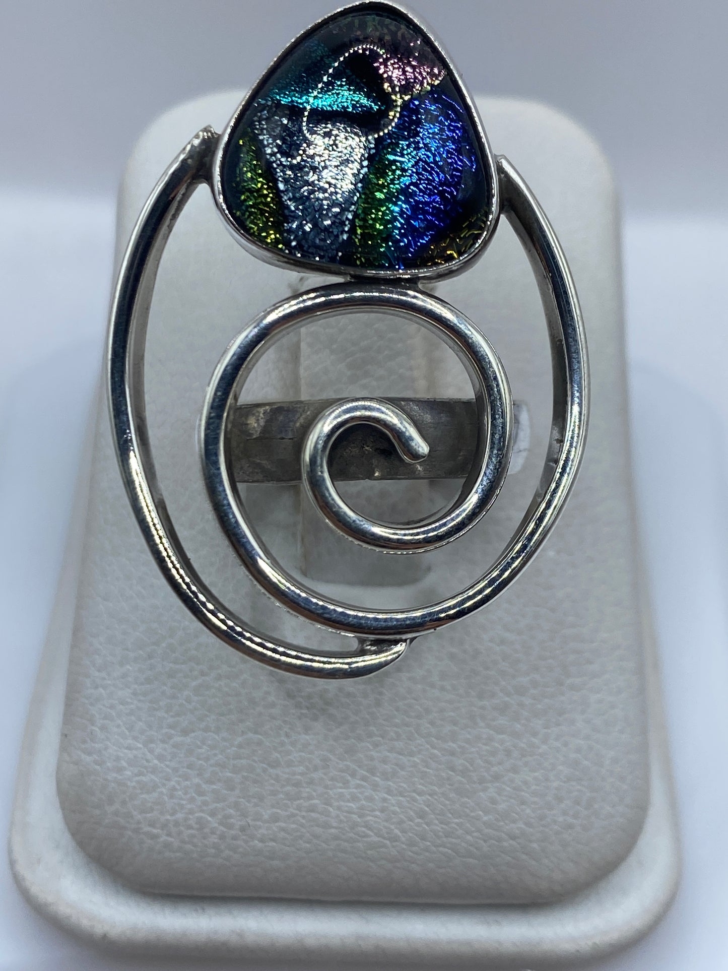 Anillo de plata espiral con incrustación de piedra multicolor en dedo de mujer