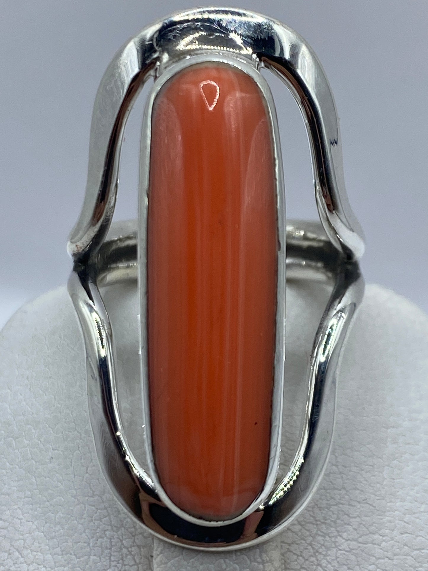 Anillo de coral en plata luciendo en dedo, mostrando el color cálido naranja rojizo