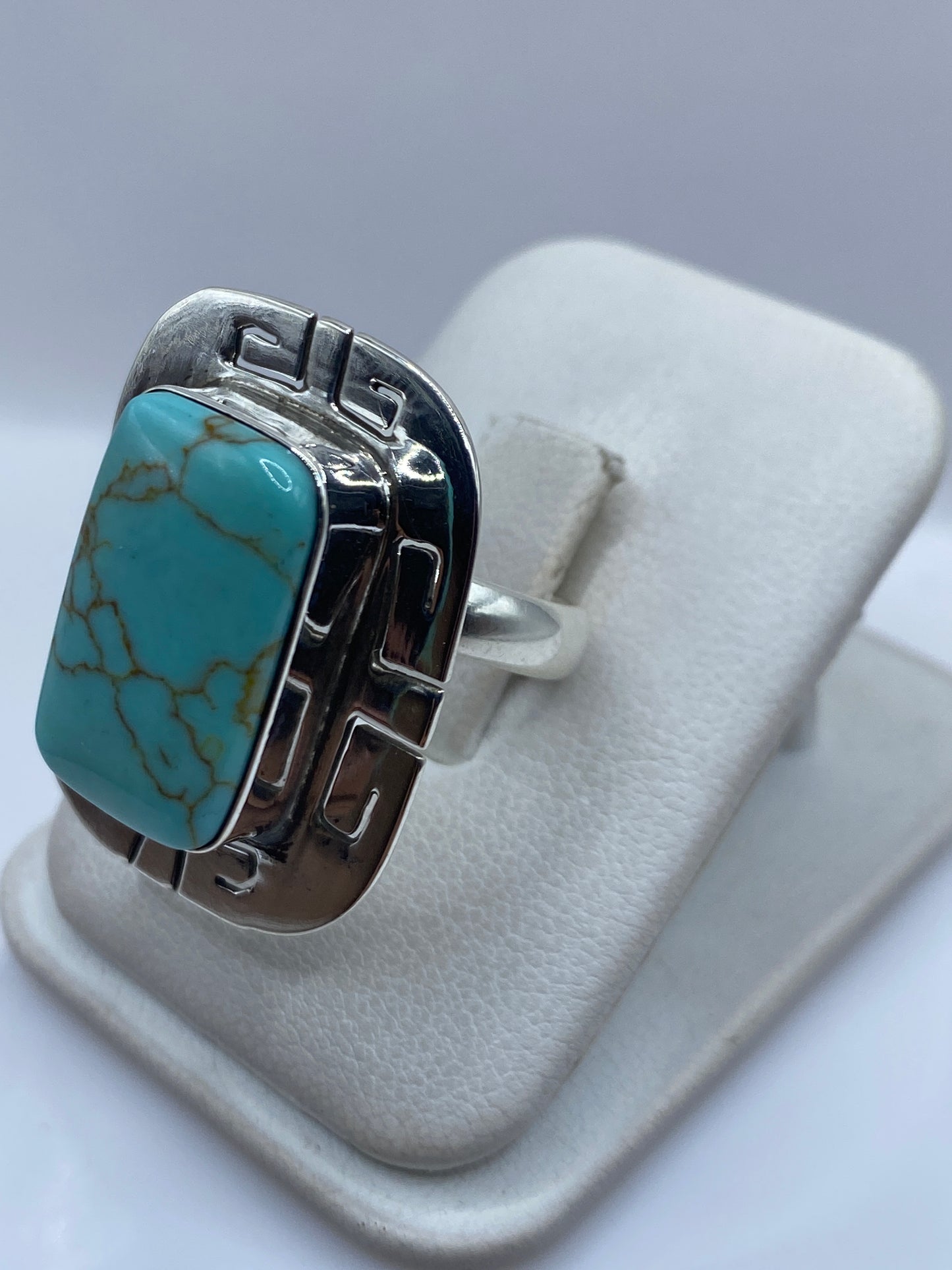 Detalle lateral del anillo de turquesa mostrando el engaste a mano en plata .925