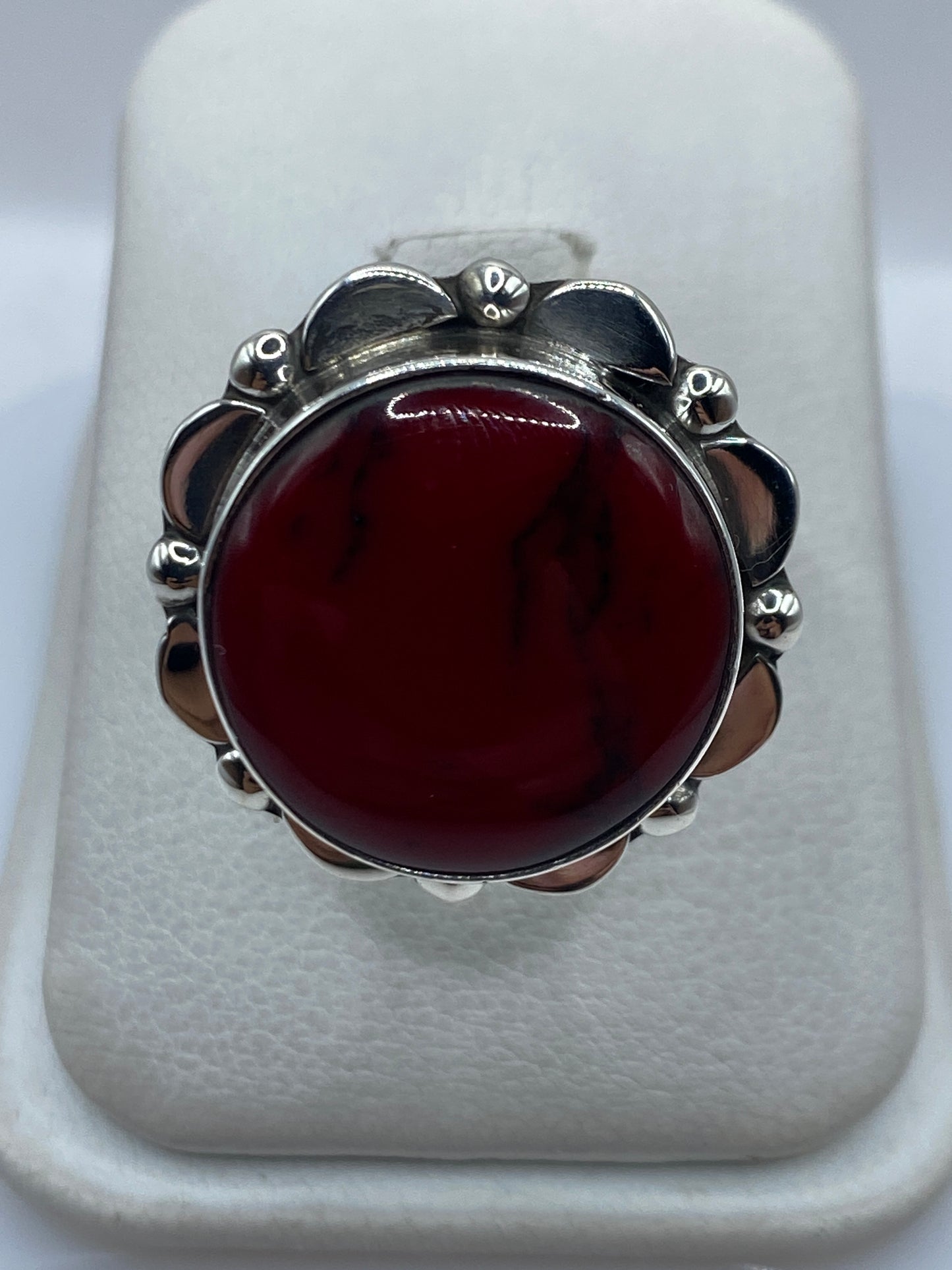 Anillo de plata con coral rojo engastado en marco de pétalos artesanal, frente