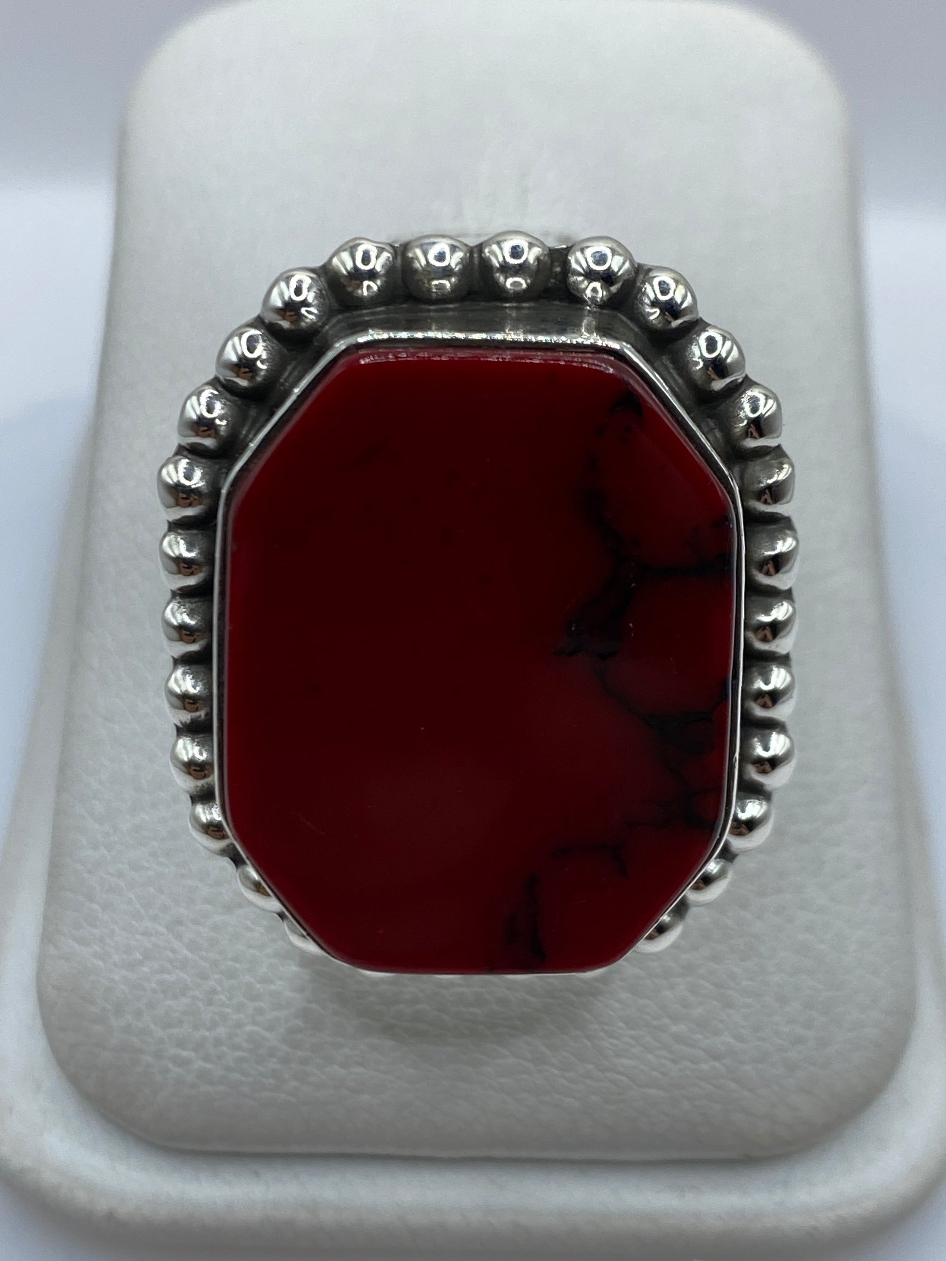 Anillo de plata .925 con coral rojo engastado, visto de frente sobre fondo blanco