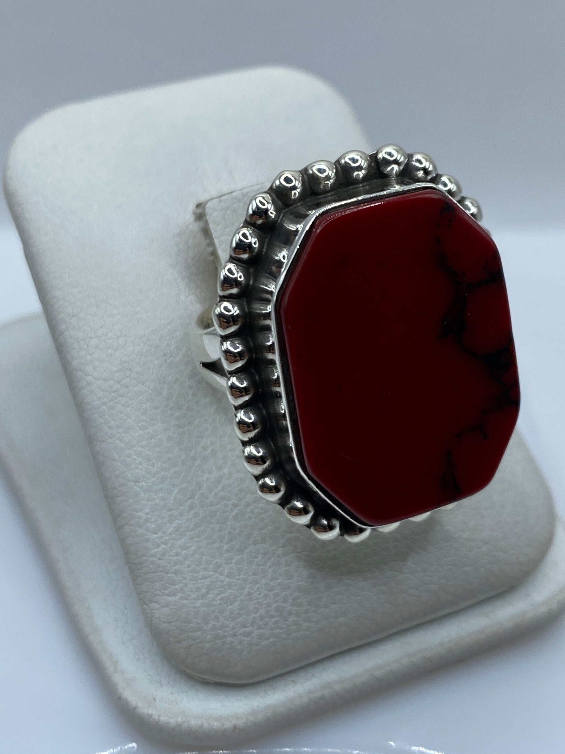 Vista lateral del anillo de plata con granulado y coral rojo
