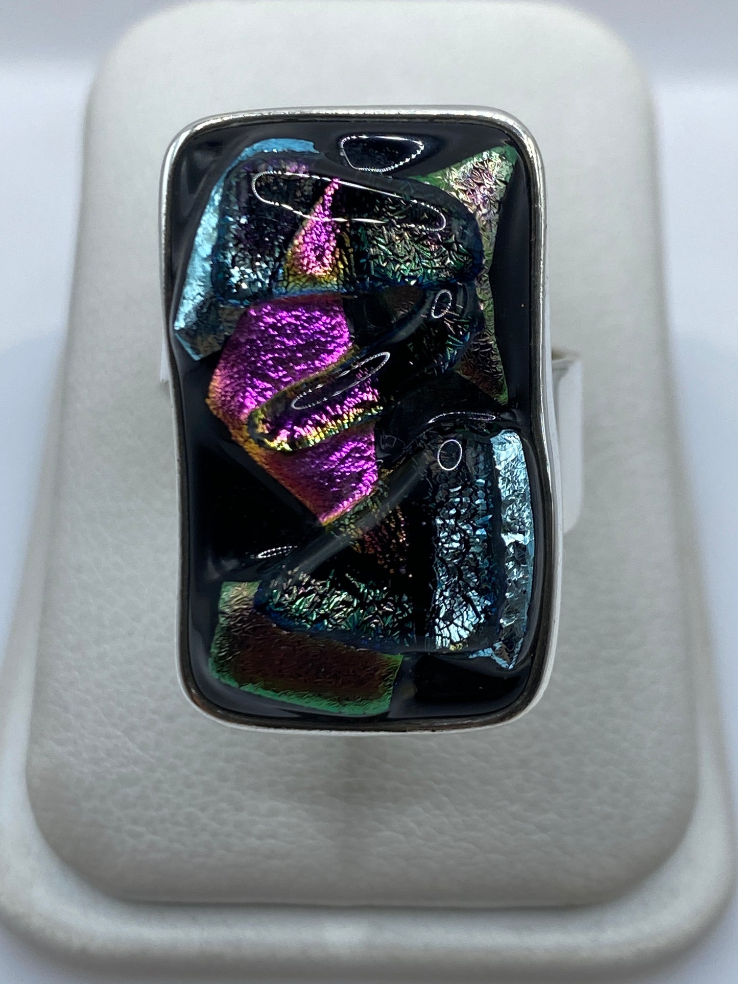 Anillo de plata .950 ajustable con piedras multicolor en tonos púrpura, azul, verde y rosa sobre fondo blanco