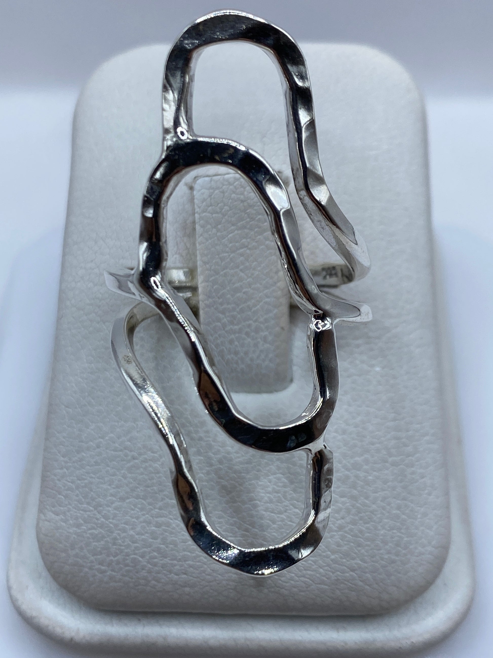 Anillo de plata repujado con diseño fluido en relieve, visto desde arriba