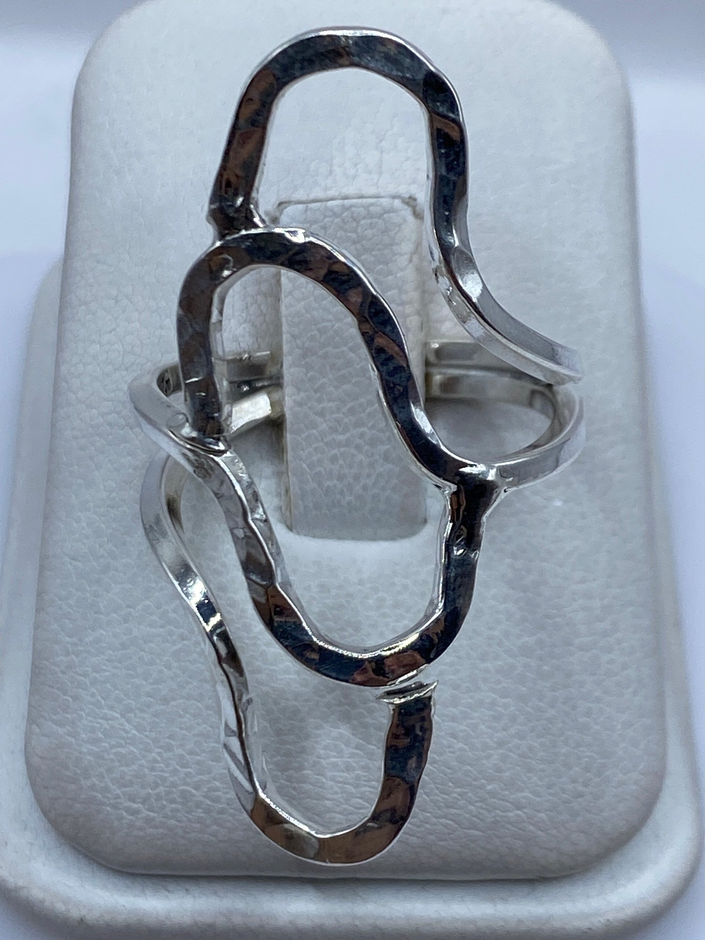 Anillo de plata repujada minimalista en la mano de una mujer
