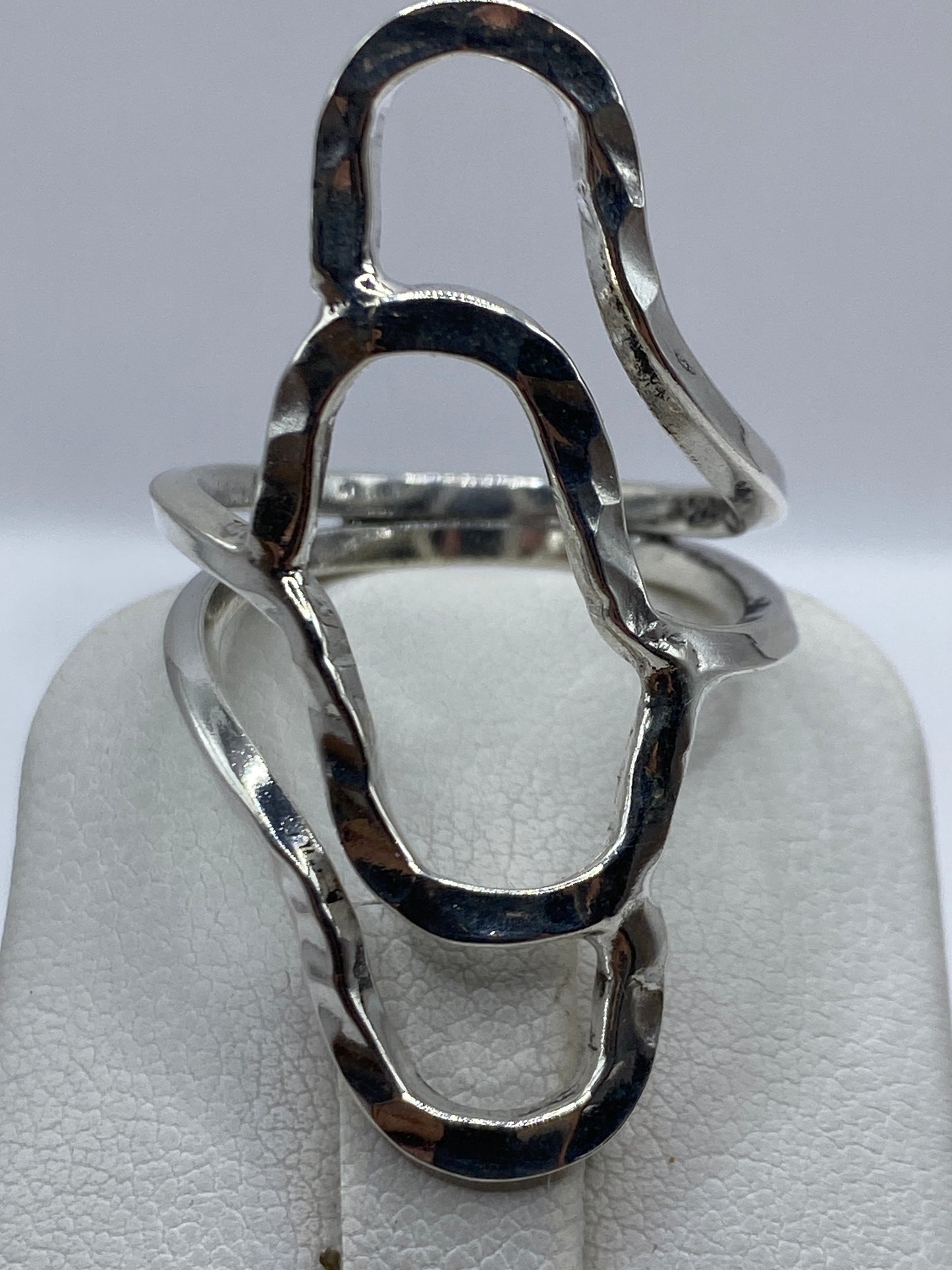 Anillo de plata en la mano, mostrando cómo captura la luz en el diseño de volumen