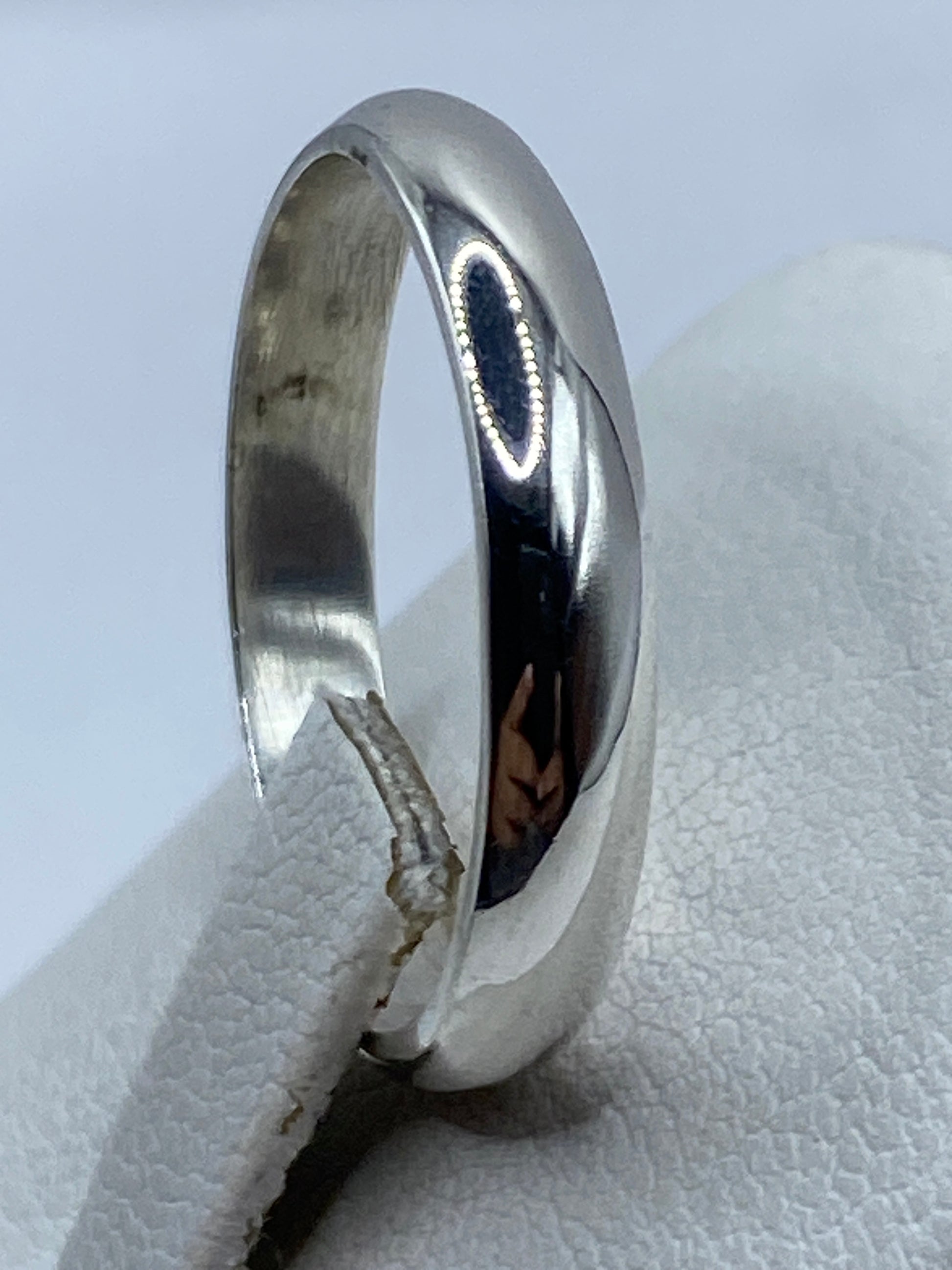 Anillo de plata en el dedo mostrando su acabado espejo y ligereza