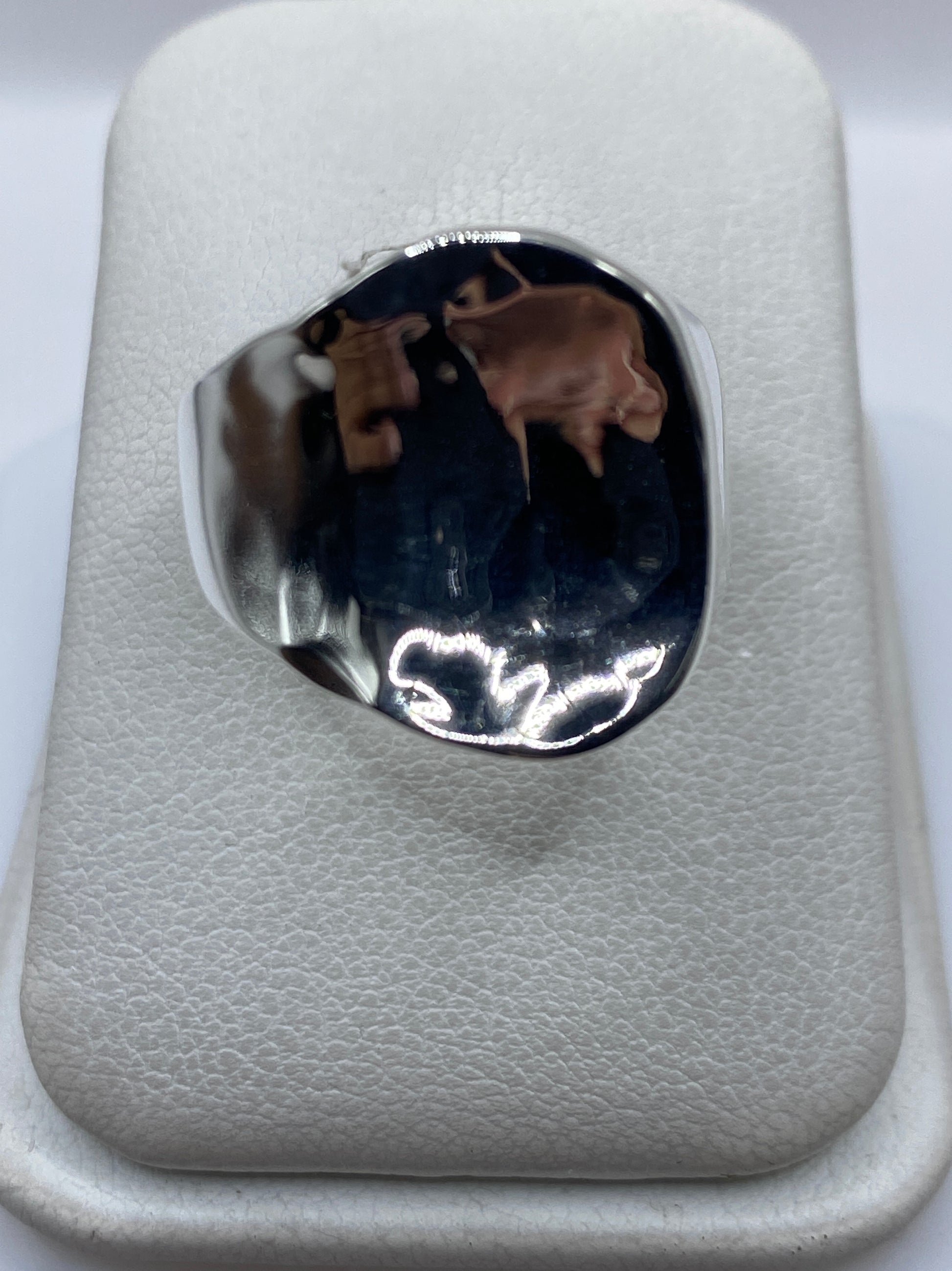 Anillo de plata repujado con relieve geométrico en la mano de una mujer