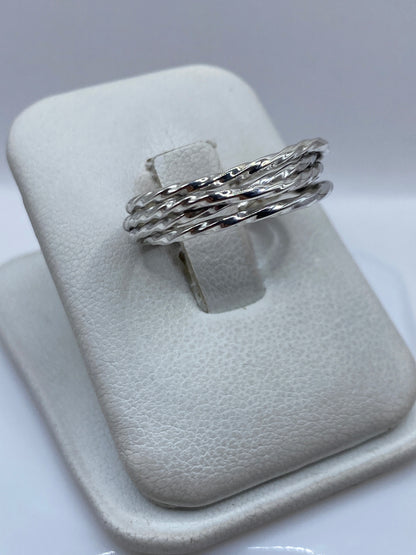 Detalle lateral del anillo mostrando las bandas trenzadas y el pulido brillante