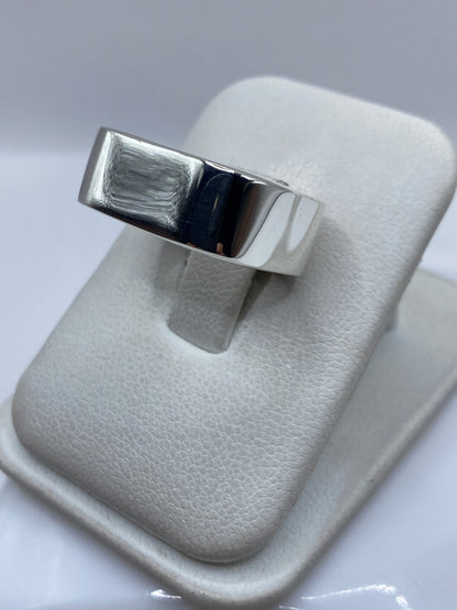 Anillo de plata en cartoneado de Taxco en la mano, mostrando volumen y peso