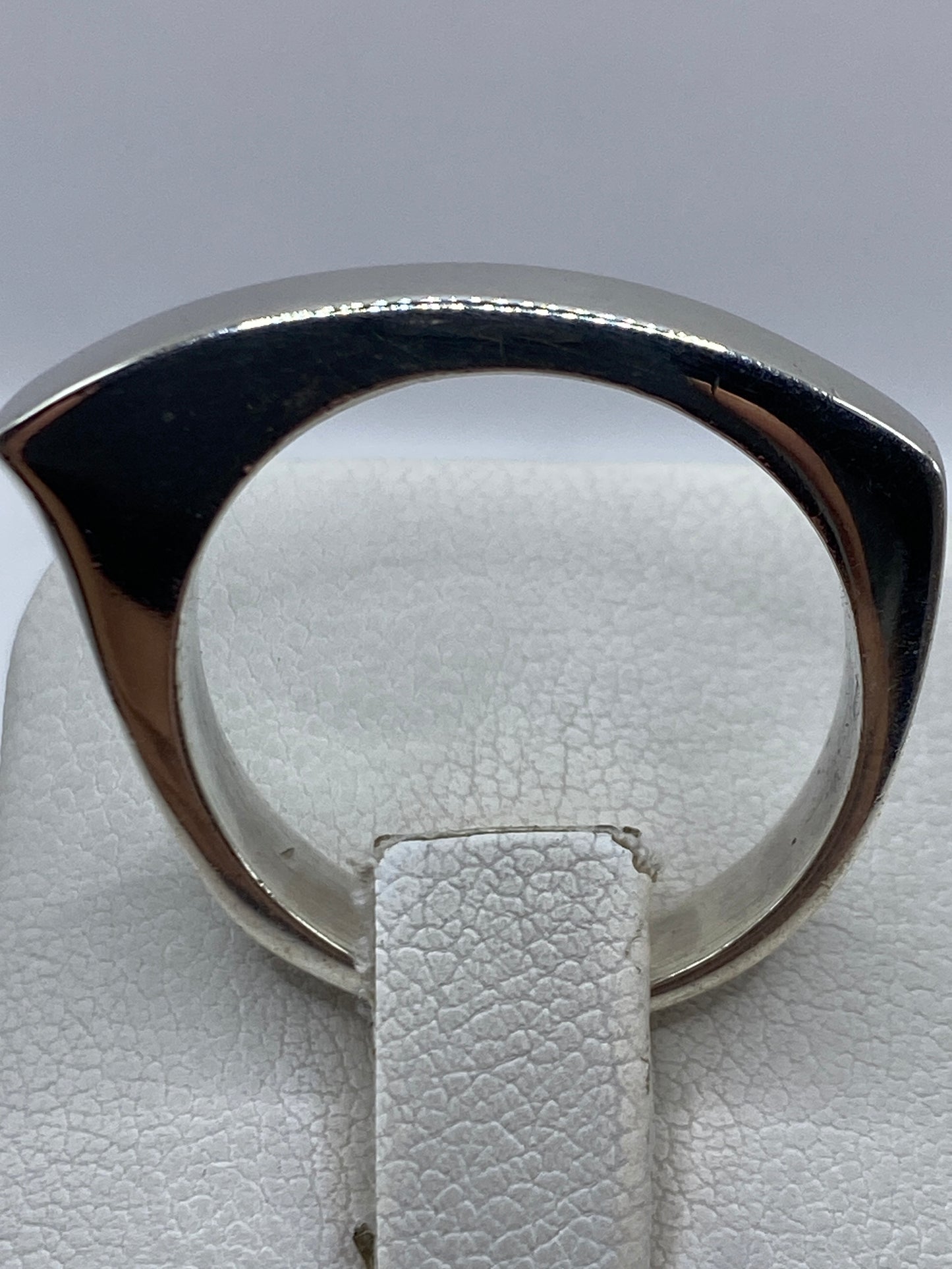 Detalle del anillo sobre dedo, mostrando la presencia y el pulido de la plata .925