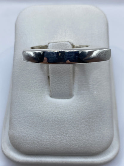 Anillo de plata cartoneado minimalista en mano, mostrando el volumen 3D