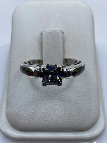 Anillo de plata .950 con ópalo de fuego multicolor visto de frente mostrando el juego de luces verdes, amarillas y rojas