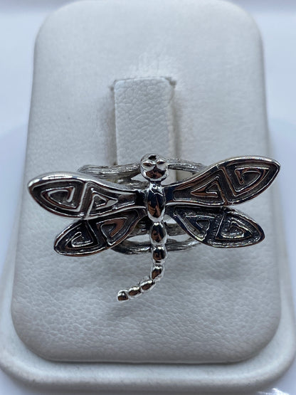 Anillo de plata libélula con alas abiertas y detalle étnico en la mano de una mujer