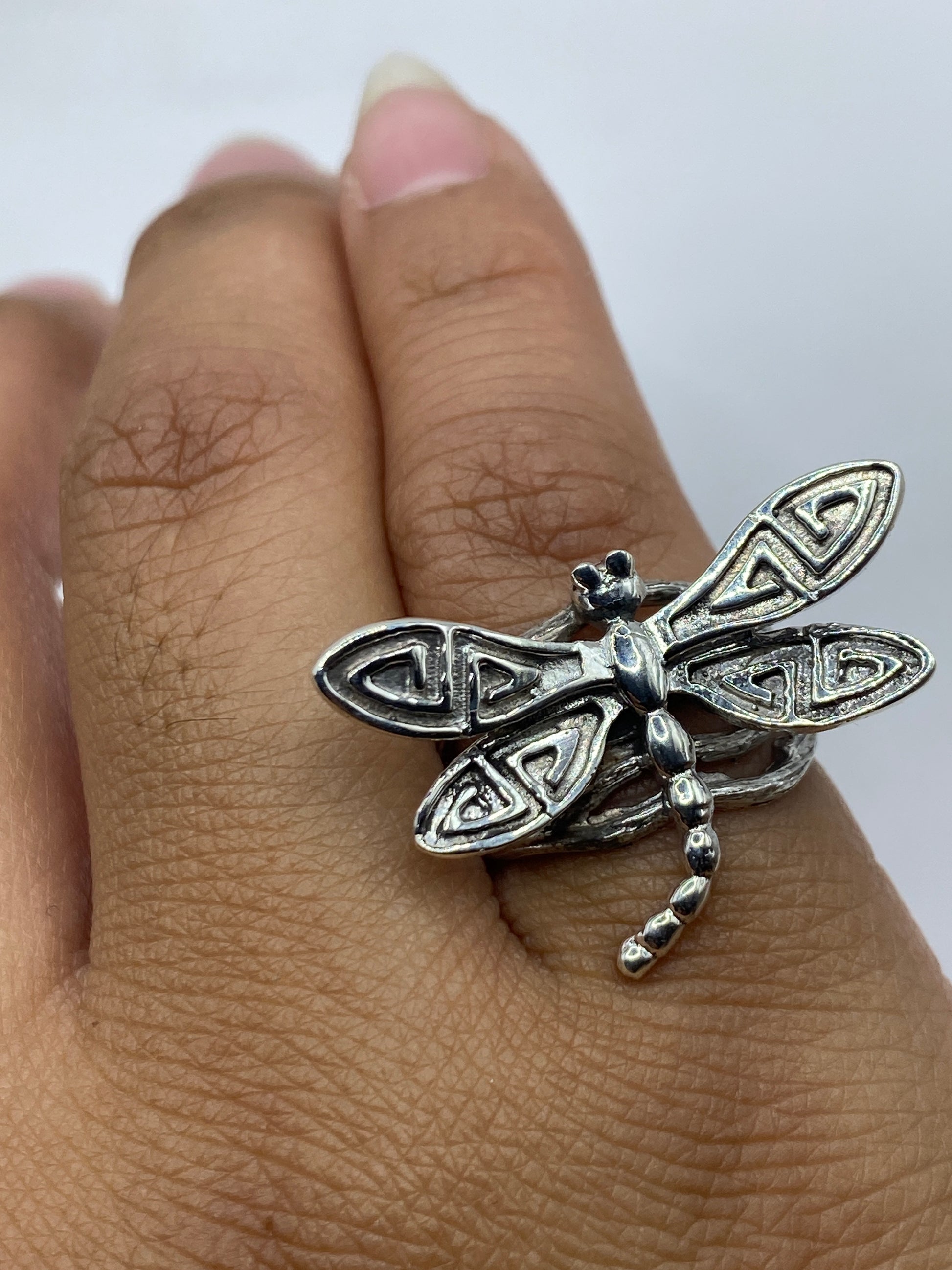 Anillo libélula sobre fondo blanco con iluminación que resalta los detalles