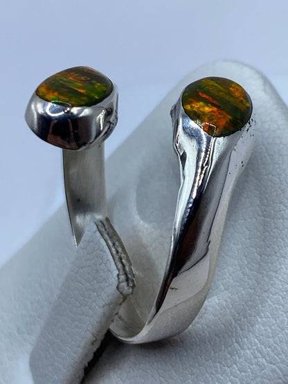 Anillo ajustable sobre dedo femenino con ópalo brillando en luz natural