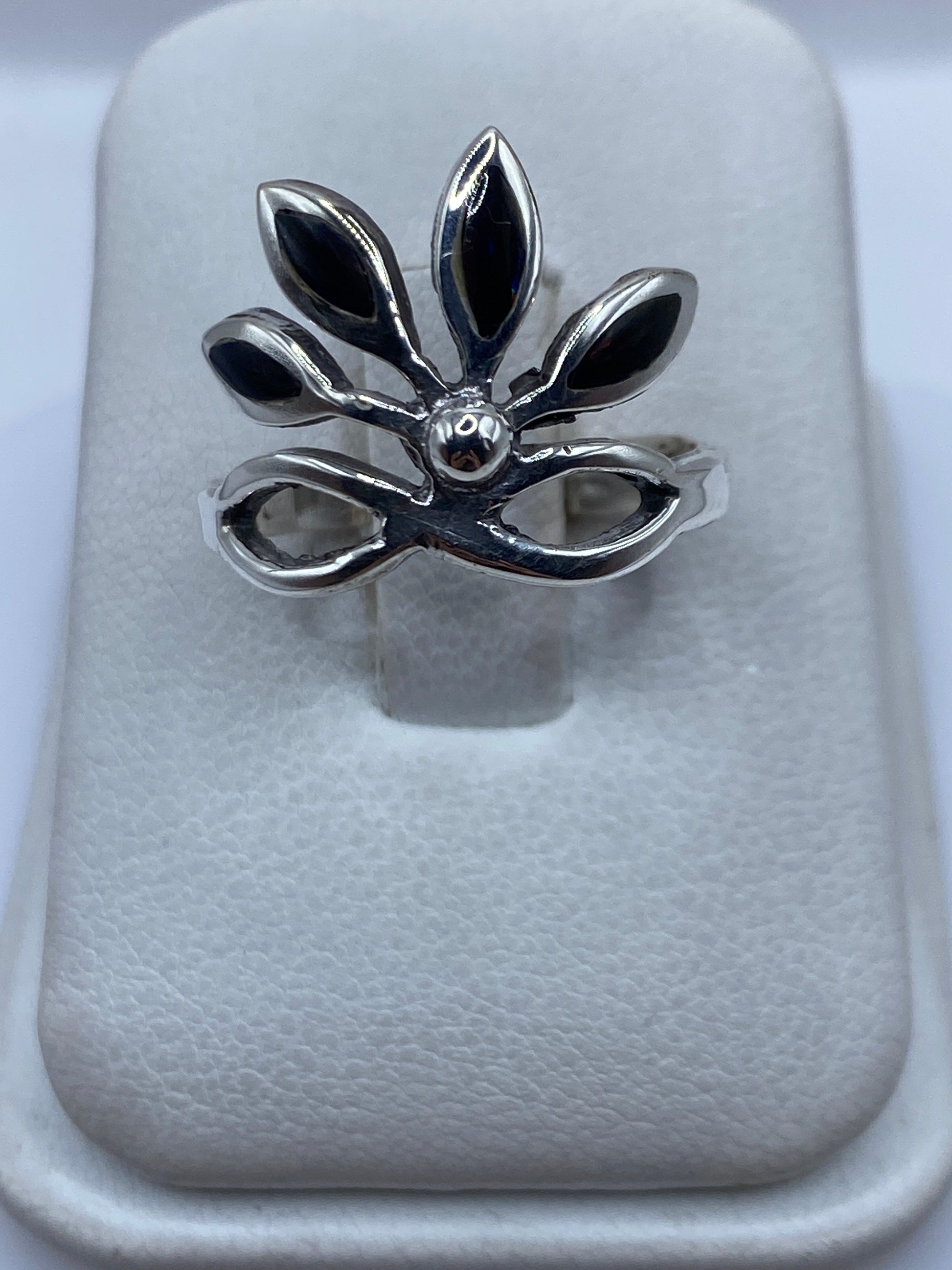 Anillo de plata con ópalo de fuego multicolor en forma floral sobre dedo