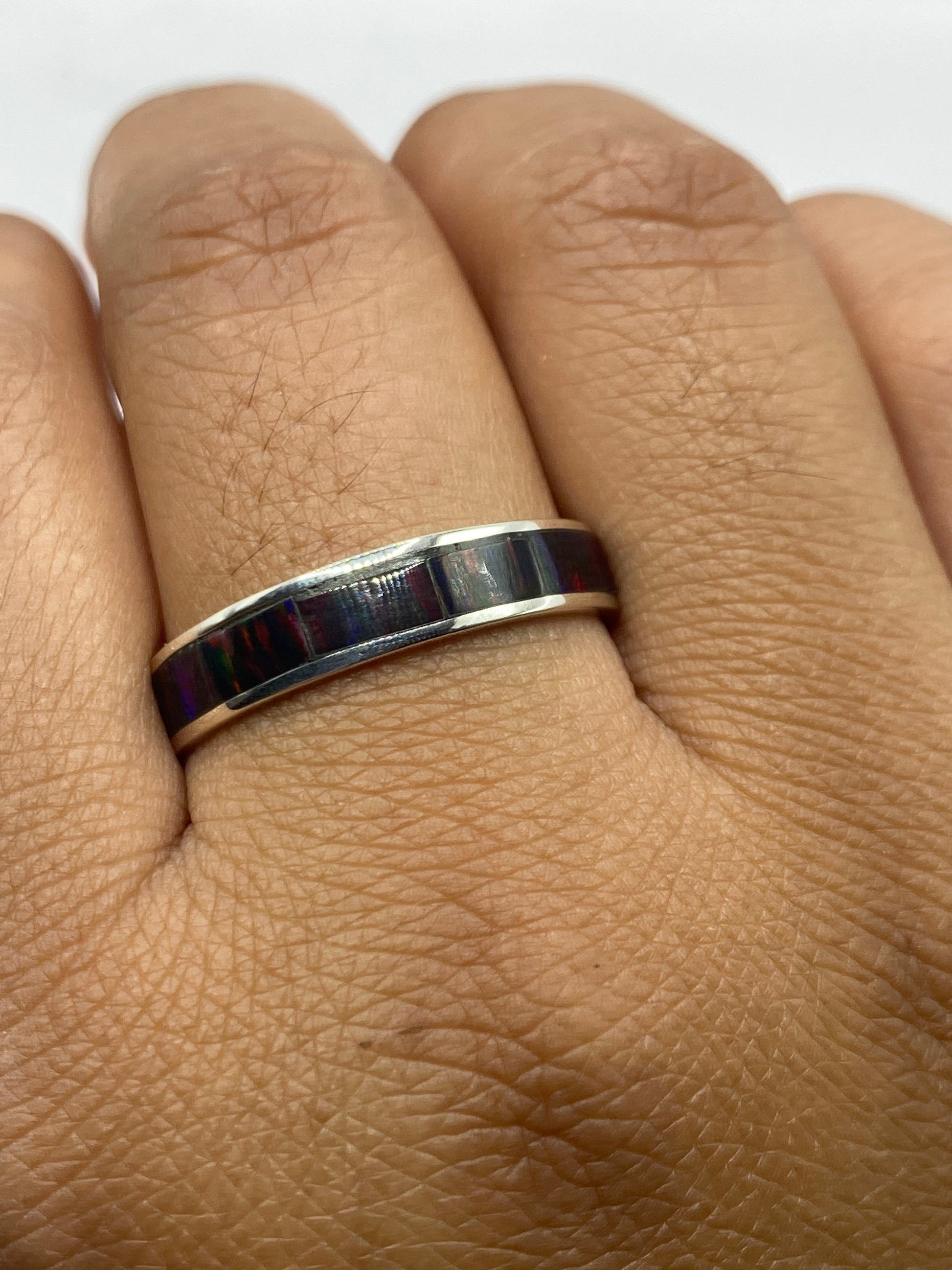 Anillo en dedo mostrando el juego de colores del ópalo de fuego en luz natural