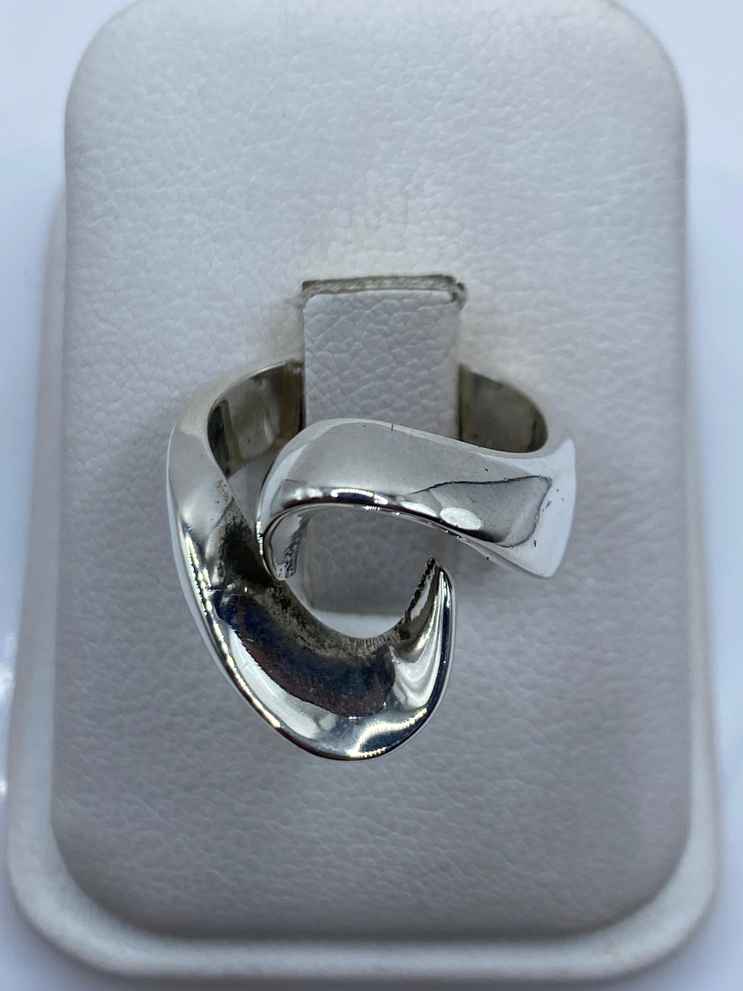 Anillo escultórico de plata pura en caja de presentación blanca, vista superior