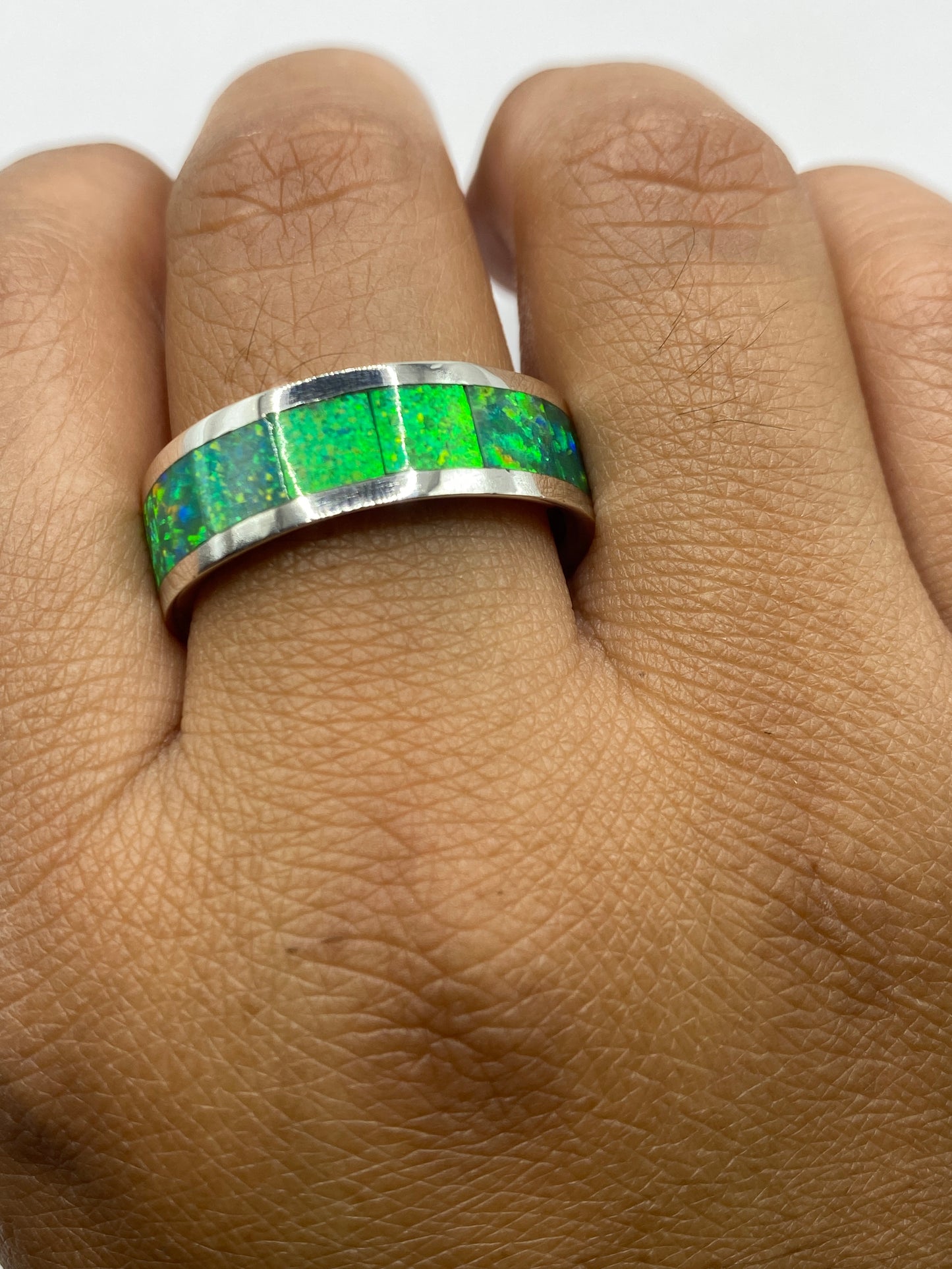 Anillo sobre fondo gris mostrando la transparencia y el fuego del ópalo