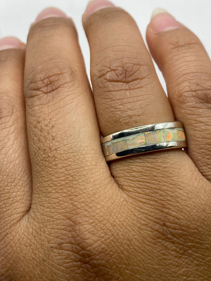 Anillo sobre dedo mostrando el juego de colores del ópalo bajo luz natural