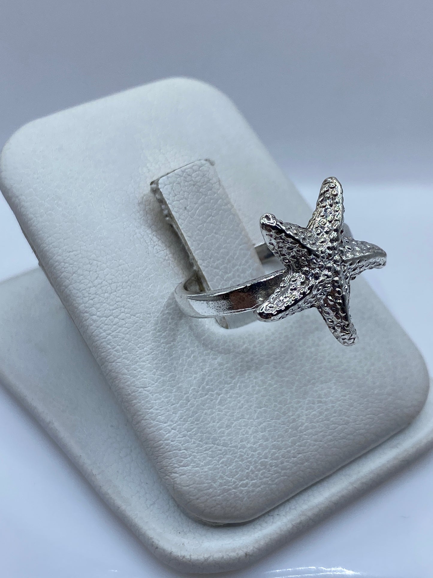 Anillo estrella de mar en plata en la mano, mostrando el brillo y detalle