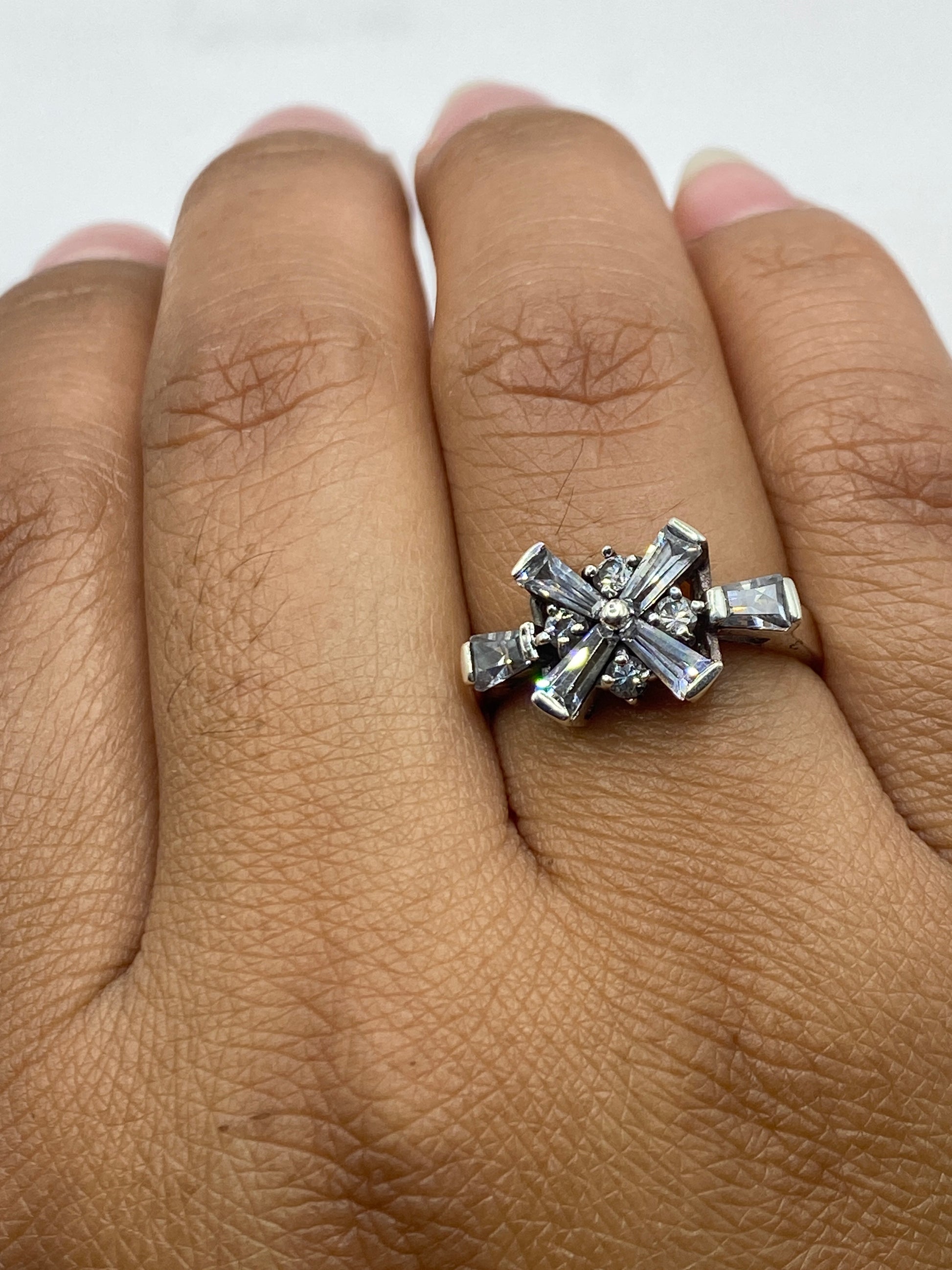 Anillo en dedo mostrando el brillo de las circonias y la plata pulida de Taxco