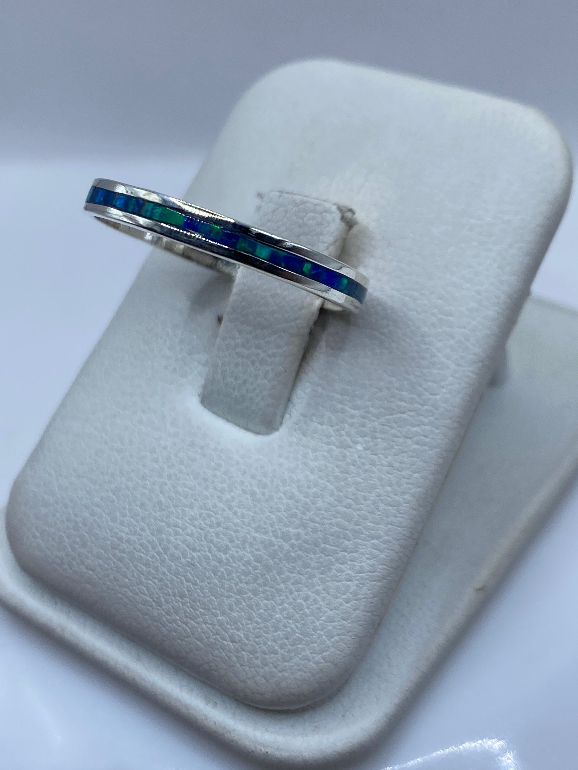 Detalle lateral del anillo mostrando el engaste a mano del ópalo azul