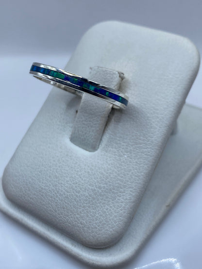 Detalle lateral del anillo mostrando el engaste a mano del ópalo azul
