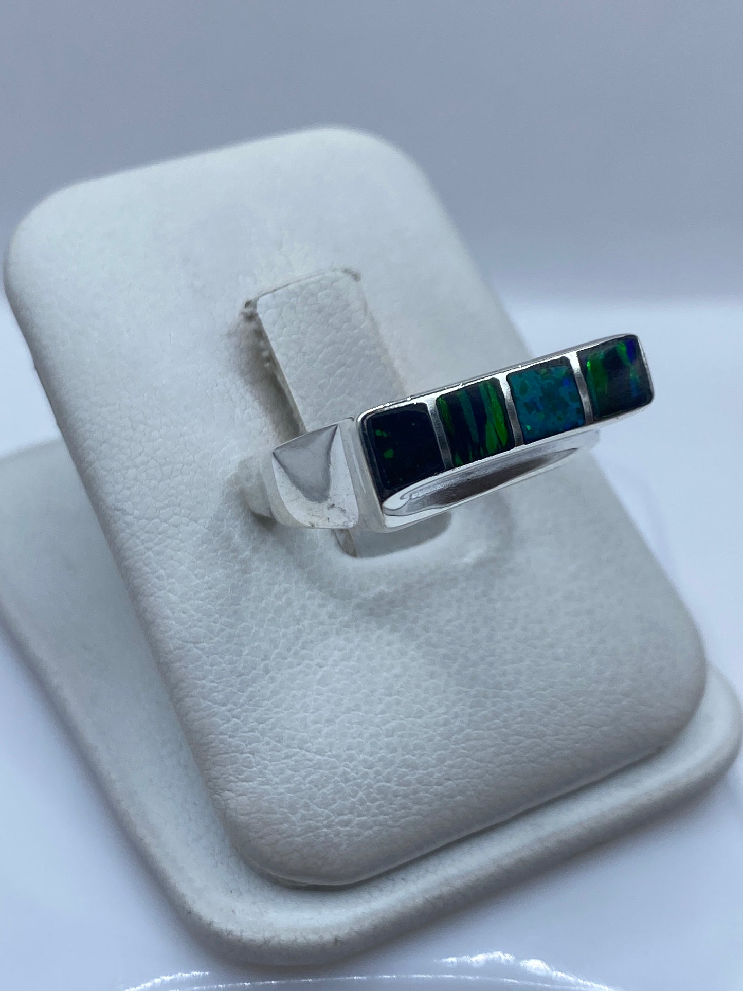 Detalle del Ópalo de Fuego azul con destellos verdes en el engaste de plata