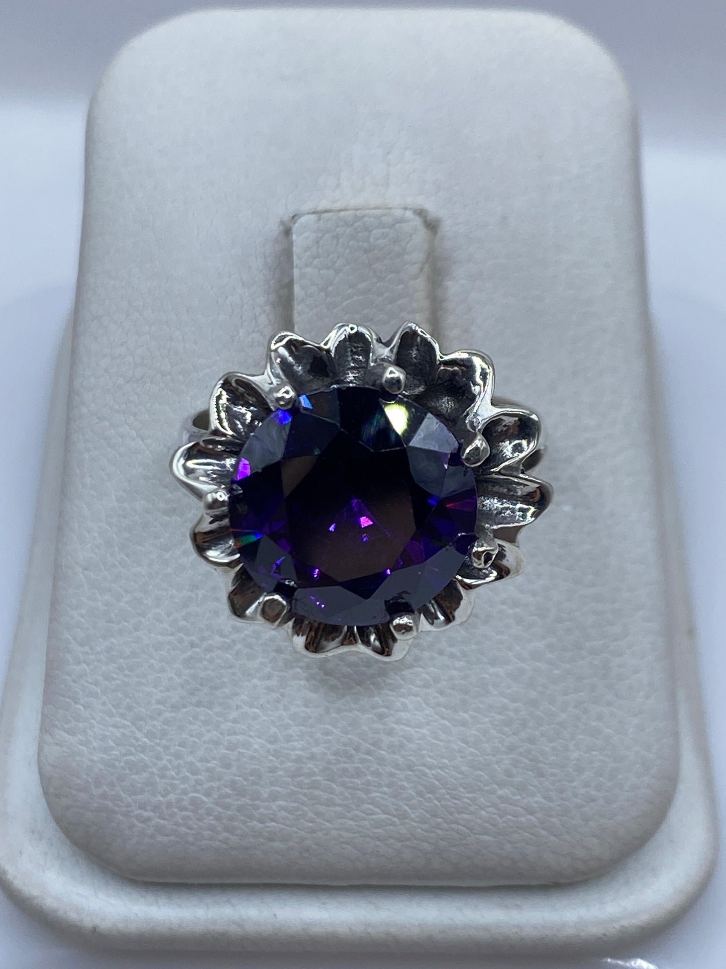 Anillo de plata con circonia morada en corona floral, vista frontal en estuche
